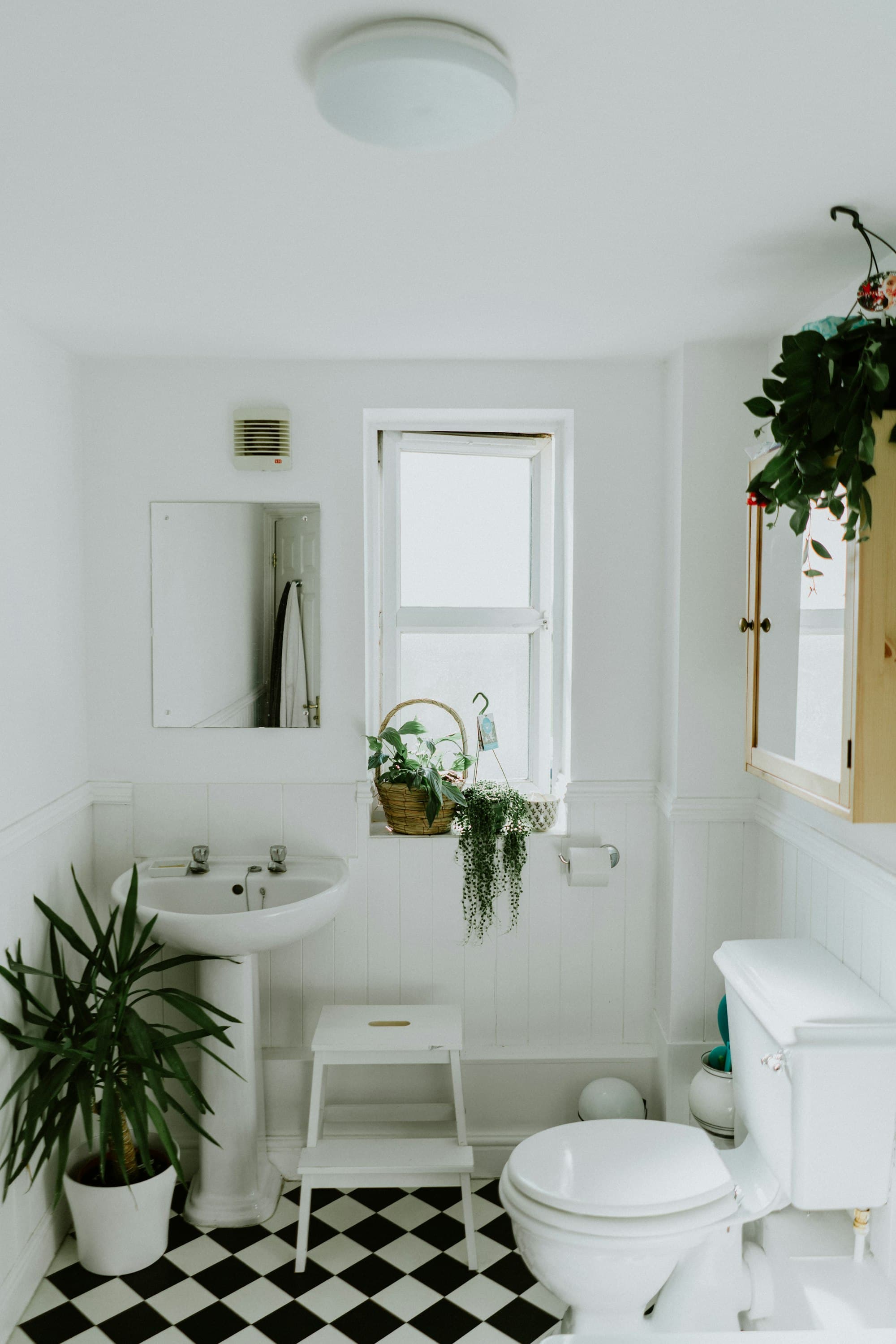 Bathroom with white tile, a freestanding tub, and a wood vanity